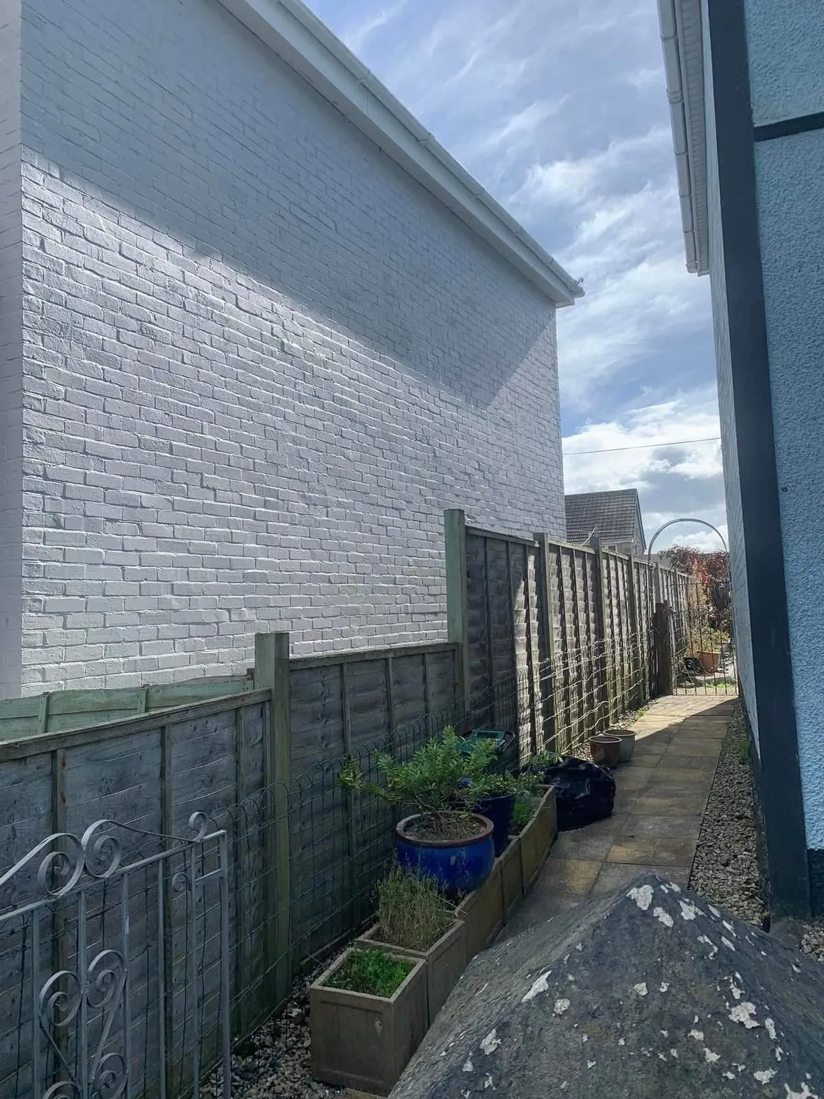 Freshly painted brick wall after preparation and masonry paint in Budleigh Salterton